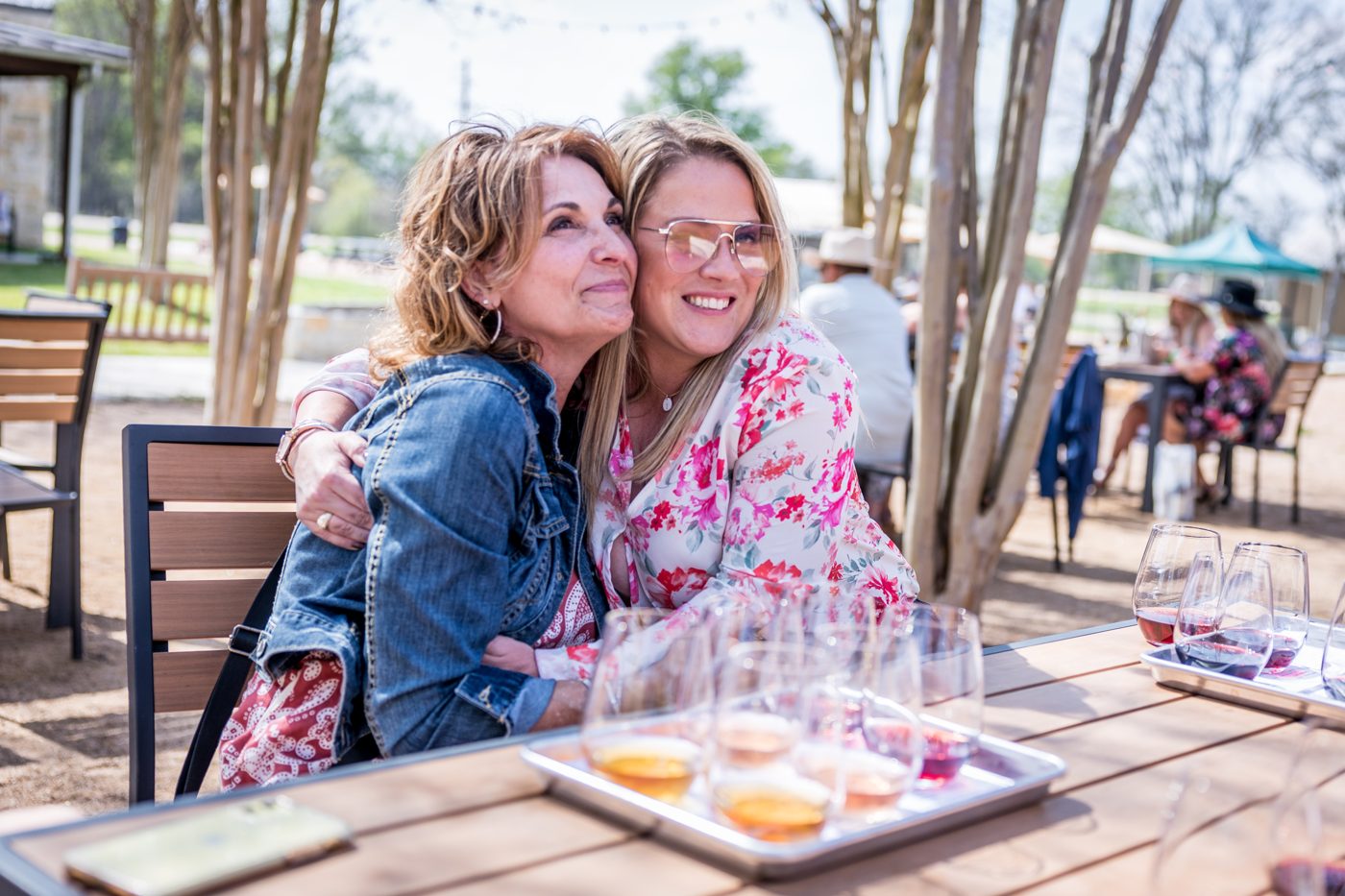 Mother and daughter sharing a hug over a tasting flight on tour